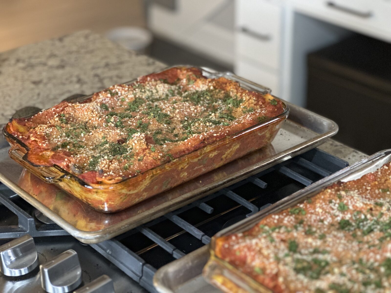 Two pans of plant-based lasagna fresh from the oven, golden and bubbling